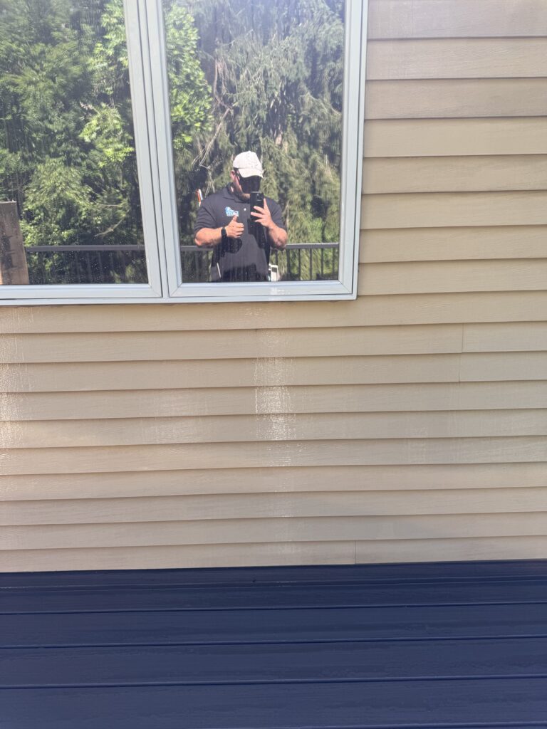 Reflection in a square window with greenery outside after being washed by Wiley's pressure Washing Services in Madison, OH