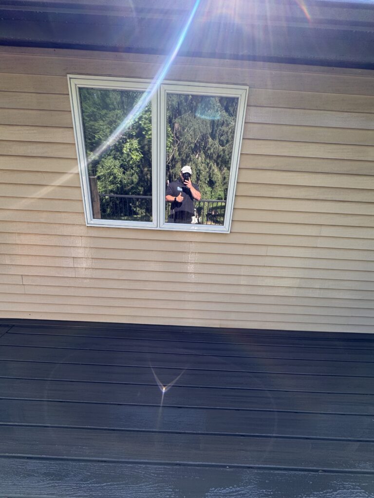 Reflection in a square window with greenery outside after being washed by Wiley's pressure Washing Services in Madison, OH